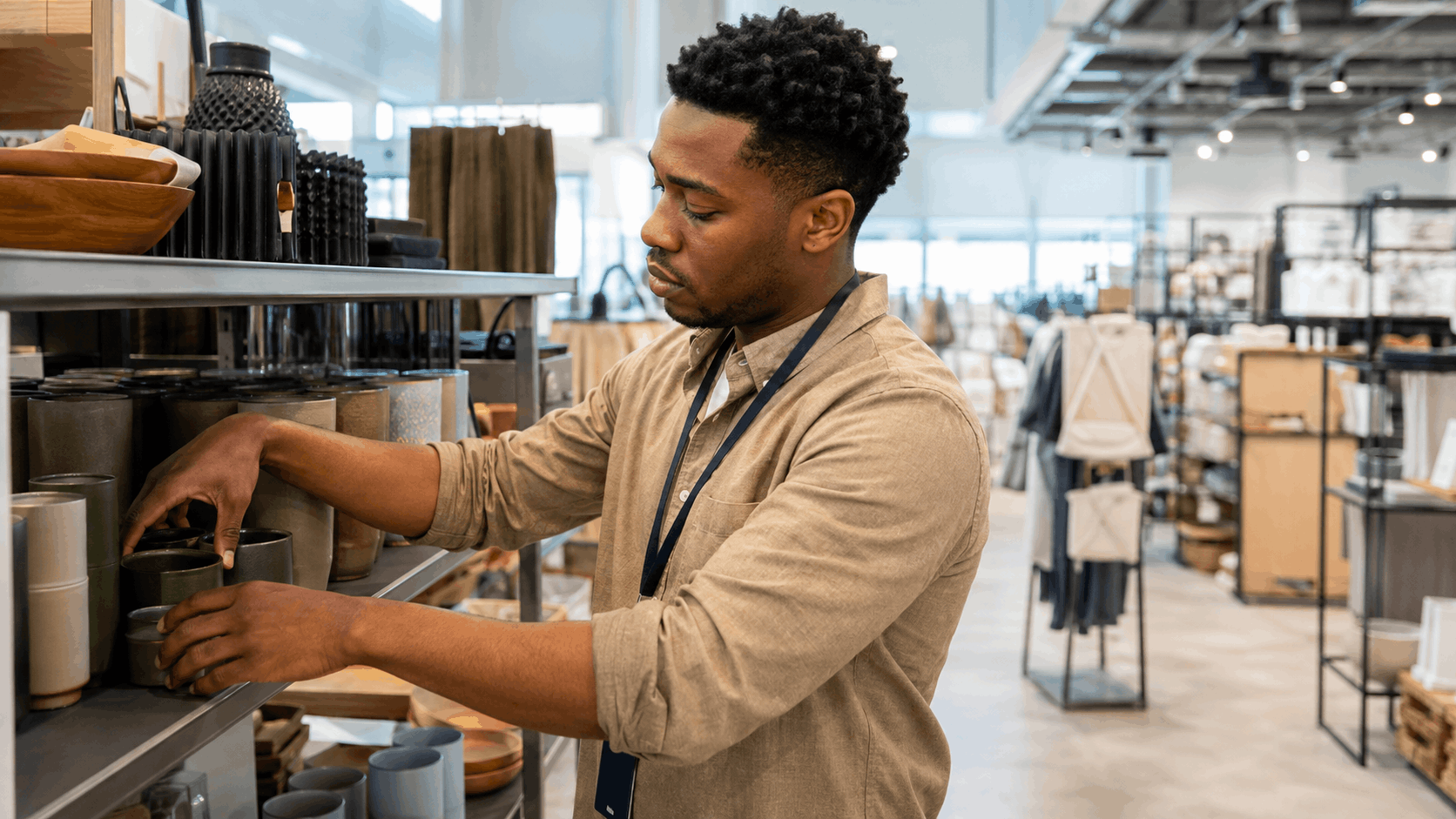 A retail manager arranging stock on a shelf in a homeware store
