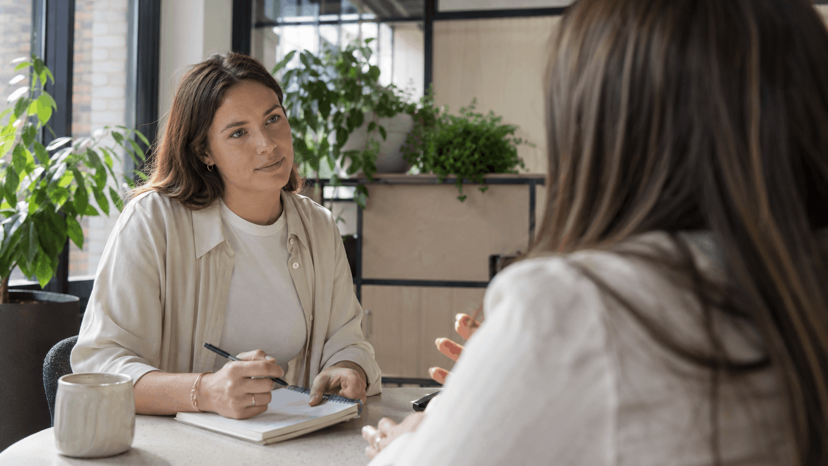 An HR recruiter taking notes while interviewing a candidate