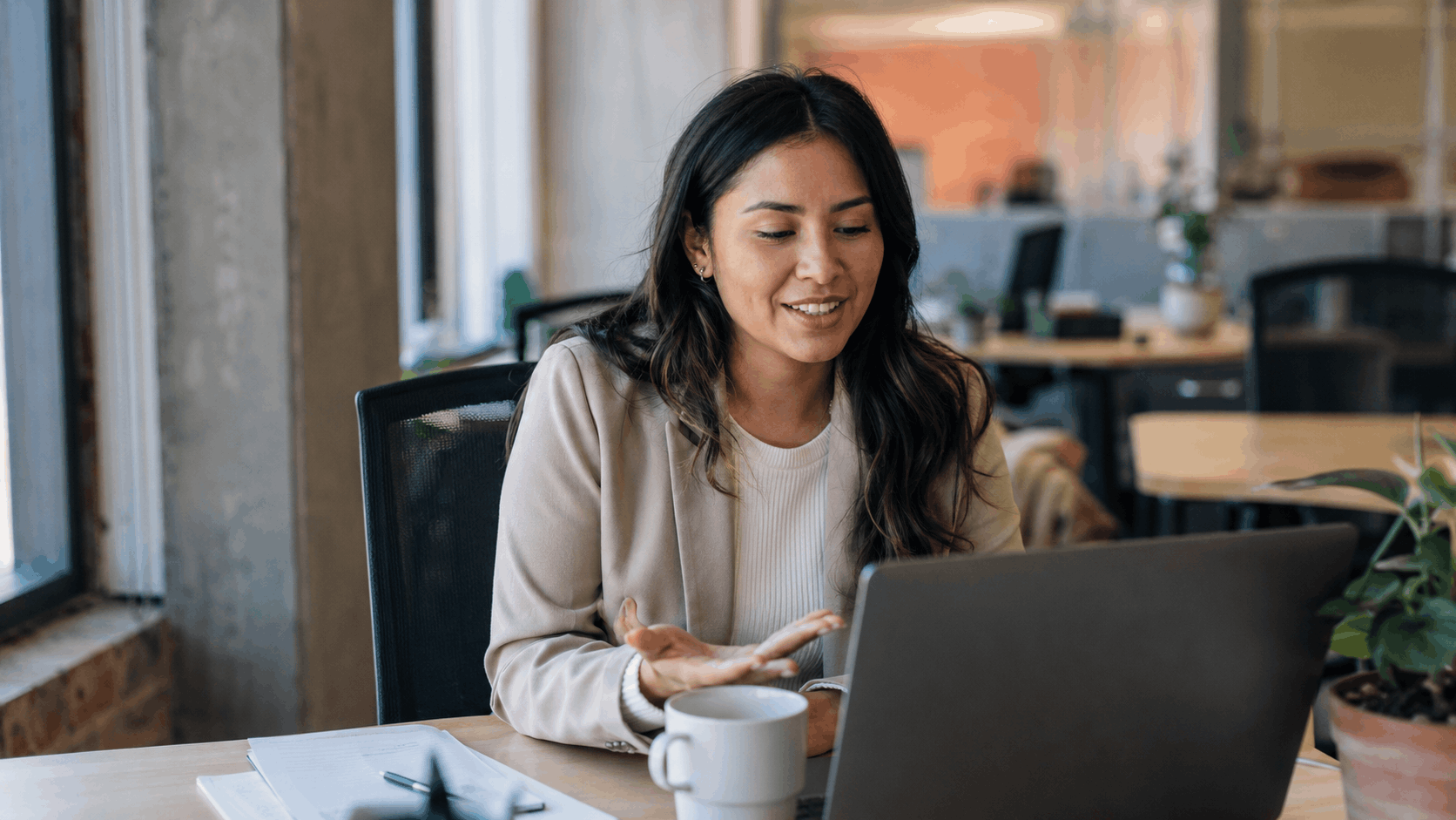 An account manager on a video call with a client at her desk